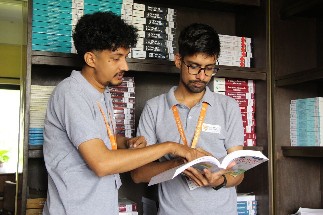 Two South Asian students engaged in a study session at a university library, Nepal.
